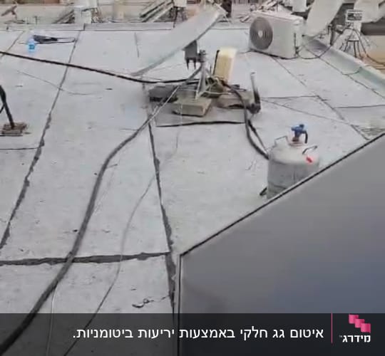 גג עם יריעות איטום, צינורות ומיכל גז